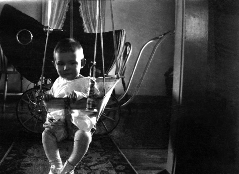 Donn Gene Hanneman, son of Carl F. Hanneman (1901-1982) and Ruby V. (Treutel) Hanneman (1904-1977), sits in an indoor baby swing at the Hanneman home in Fond du Lac, Wis, ca. 1927. Carl Hanneman was a pharmacist for the Staeben Drug Co. in Fond du Lac at the time.