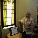 Mary K. Hanneman next to one of the window sections she and the late David D. Hanneman donated to St. Mary's Hospital.